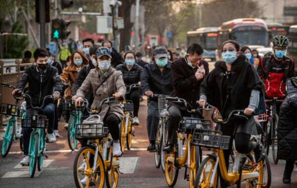 Chinese commuters ride bikes and scooters in the central business district during rush hour in Beijing on April 7, 2020. (Kevin Frayer/Getty Images)