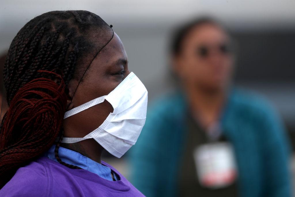 Alameda Health System nurses, doctors, and workers wear personal protective equipment (PPE) during a protest asking for better working conditions and PPE in front of Highland Hospital in Oakland, Calif., on March 26, 2020. (Justin Sullivan/Getty Images)