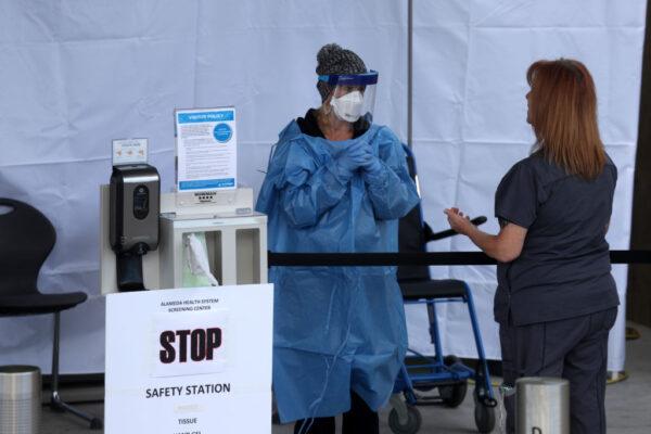 A file photo of healthcare professionals screening people entering the emergency room at Highland Hospital in Oakland, Calif., on March 26, 2020. (Justin Sullivan/Getty Images)