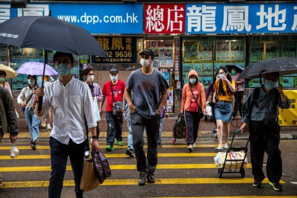 ImpactHK founder and CEO Jeff Rotmeyer (C) crosses a street after handing out supplies of face masks, hand sanitizers, food and drinks to the homeless and people in need in Hong Kong, China, on March 28, 2020. (Isaac Lawrence/AFP via Getty Images)