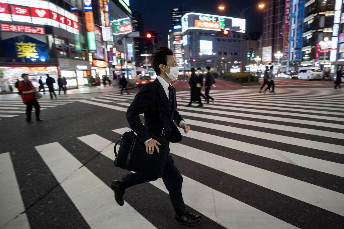 A man crosses a road in the Shinjuku district in Tokyo, Japan, on April 8, 2020. (Tomohiro Ohsumi/Getty Images)