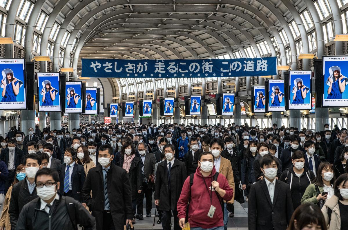 Commuters, many wearing protective masks, walk through Shinagawa train station in Tokyo, Japan, on April 8, 2020. (Carl Court/Getty Images)