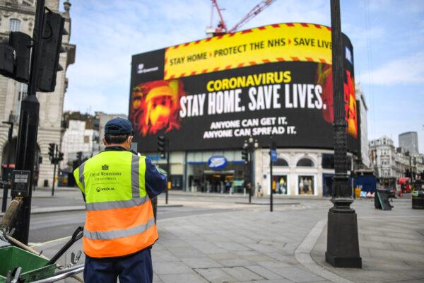 A street cleaner is seen in front of CCP virus messaging in Piccadilly Circus in London on April 8, 2020. (Peter Summers/Getty Images)