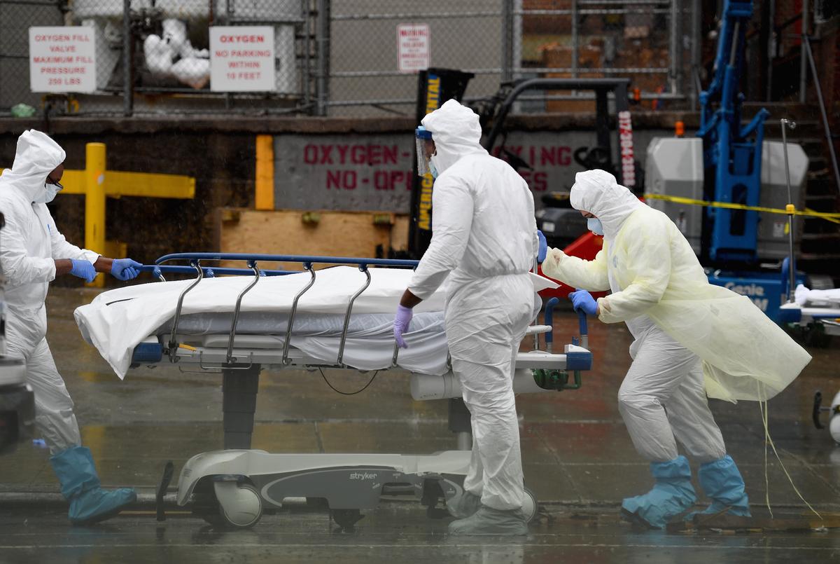 Medical personnel move a deceased patient to a refrigerated truck serving as makeshift morgues at Brooklyn Hospital Center in New York City on April 9, 2020. (Angela Weiss/AFP via Getty Images)