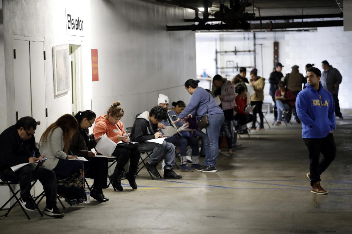 Unionized hospitality workers wait in line in a basement garage to apply for unemployment benefits at the Hospitality Training Academy in Los Angeles, Calif., on March 13, 2020. (Marcio Jose Sanchez/AP Photo)