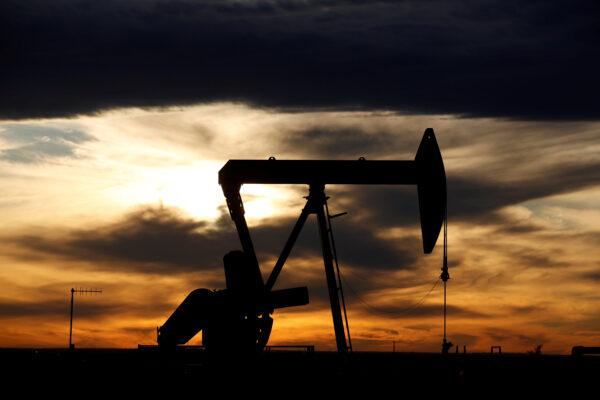 The sun sets behind a crude oil pump jack on a drill pad in the Permian Basin in Loving County, Texas, on Nov. 24, 2019. (Angus Mordant/Reuters)