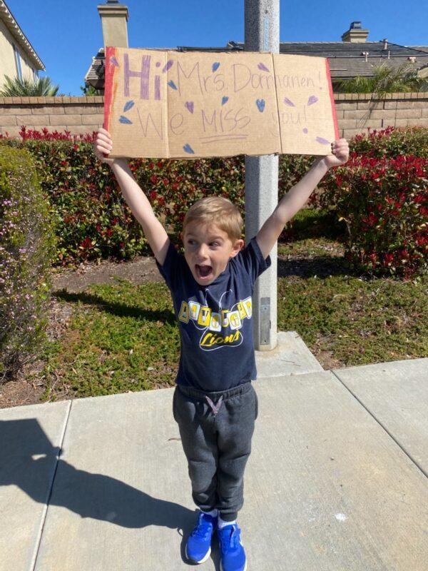 An excited student holds up a sign at a car parade organized by his teachers in French Valley, Calif. (Courtesy of Darlene Dormanen)