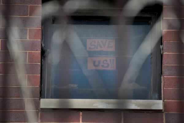 A sign pleading for help hangs in a window at the Cook County jail complex in Chicago, Ill., on April 09, 2020. (Scott Olson/Getty Images)