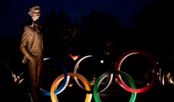 This picture shows the statue of founder of International Olympic Committee (IOC) Pierre de Coubertin and the Olympic rings in Tokyo, Japan, on April 7, 2020. (Behrouz Mehri /AFP via Getty Images)