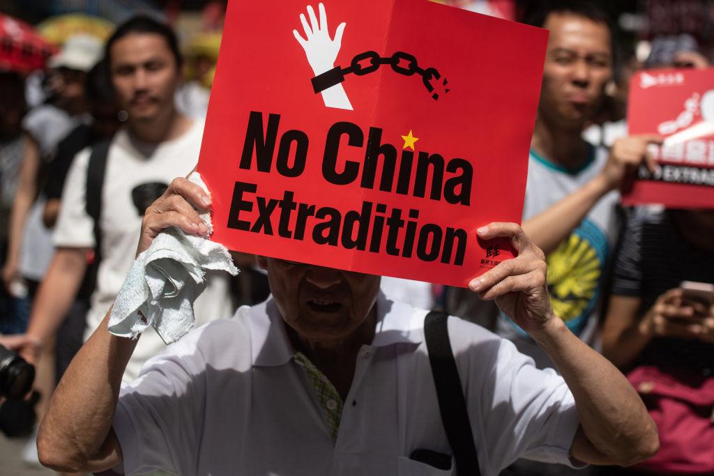 A protester marches with a placard during a rally against a controversial extradition law proposal in Hong Kong on June 9, 2019. (©Getty Images | <a href="https://www.gettyimages.com/detail/news-photo/protester-marches-with-a-placard-during-a-rally-against-a-news-photo/1148669308">PHILIP FONG/AFP</a>)