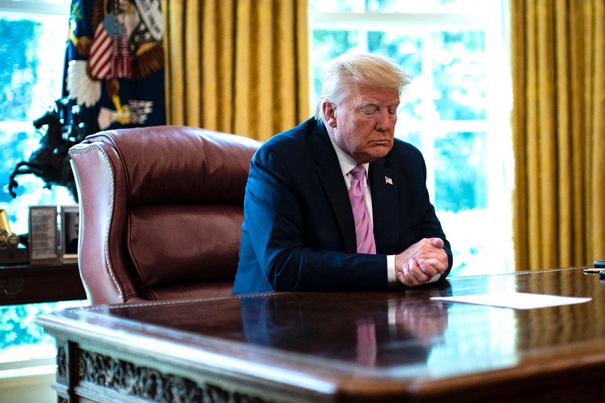 President Donald Trump bows his head during a Easter blessing by Bishop Harry Jackson, senior pastor at Hope Christian Church in Beltsville, Md., in the Oval Office of the White House on April 10, 2020. (Al Drago-Pool/Getty Images)