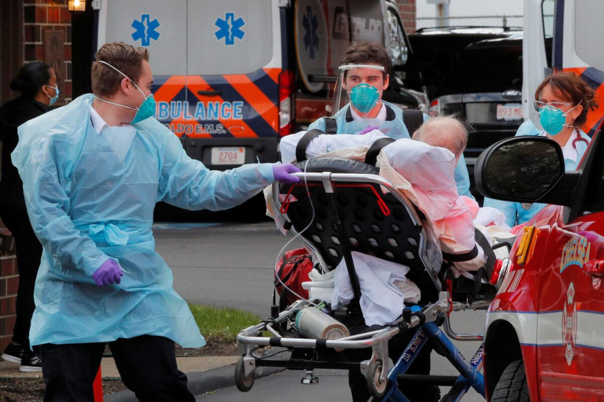 Medics attend to a patient who has tested positive for COVID-19 outside an assisted living facility in Chelsea, Massachusetts, on April 10, 2020. (Brian Snyder/Reuters)