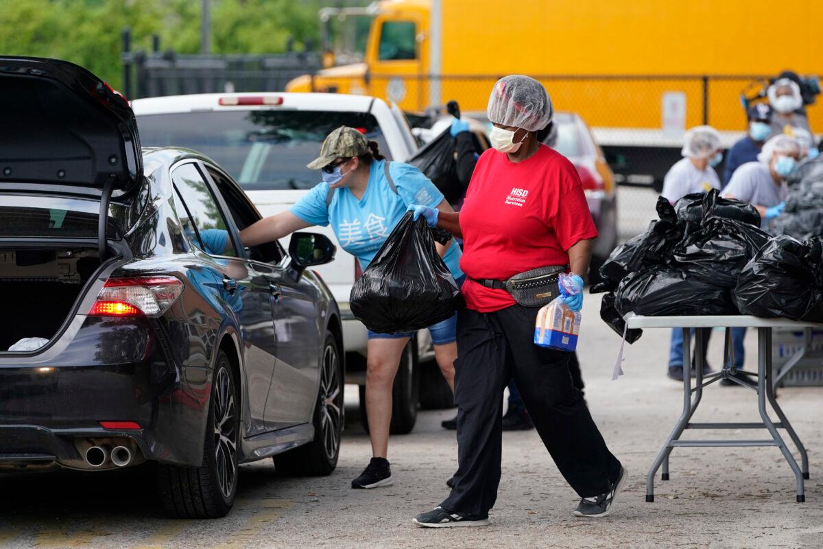 Vicky Dickson, with Houston Independent School District Nutrition Services, helps distribute food in Houston, amid the COVID-19 pandemic on April 6, 2020. (David J. Phillip/AP Photo)