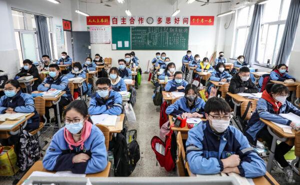 Students sit in a classroom as grade three students in middle school and high school return after the term opening was delayed due to the CCP virus outbreak in Huaian, Jiangsu province, China, on March 30, 2020. (STR/AFP via Getty Images)