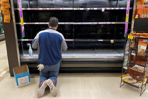 A store worker cleans an empty display for eggs inside Kroger Co.'s Ralphs supermarket amid fears of the global growth of CCP virus cases, in Los Angeles, Calif., on March 15, 2020. (Patrick T. Fallon/Reuters/File Photo)
