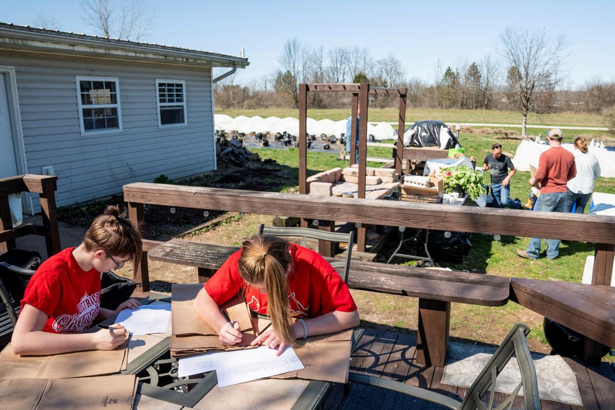 Corinne Henslee and her sister Ellen prepare orders at Front 9 Farm where they have started offering weekly deliveries of vegetables, meats, cheeses and other fresh items following the CCP virus outbreak, in Ohio, U.S., on April 4, 2020. (Dane Rhys/Reuters)