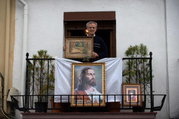Amid a national lockdown to prevent the spread of the CCP virus, Manuel, 75, poses with icons on his balcony in Ronda, Spain, on Easter Sunday on April 12, 2020. (Jorge Guerrero /AFP via Getty Images)