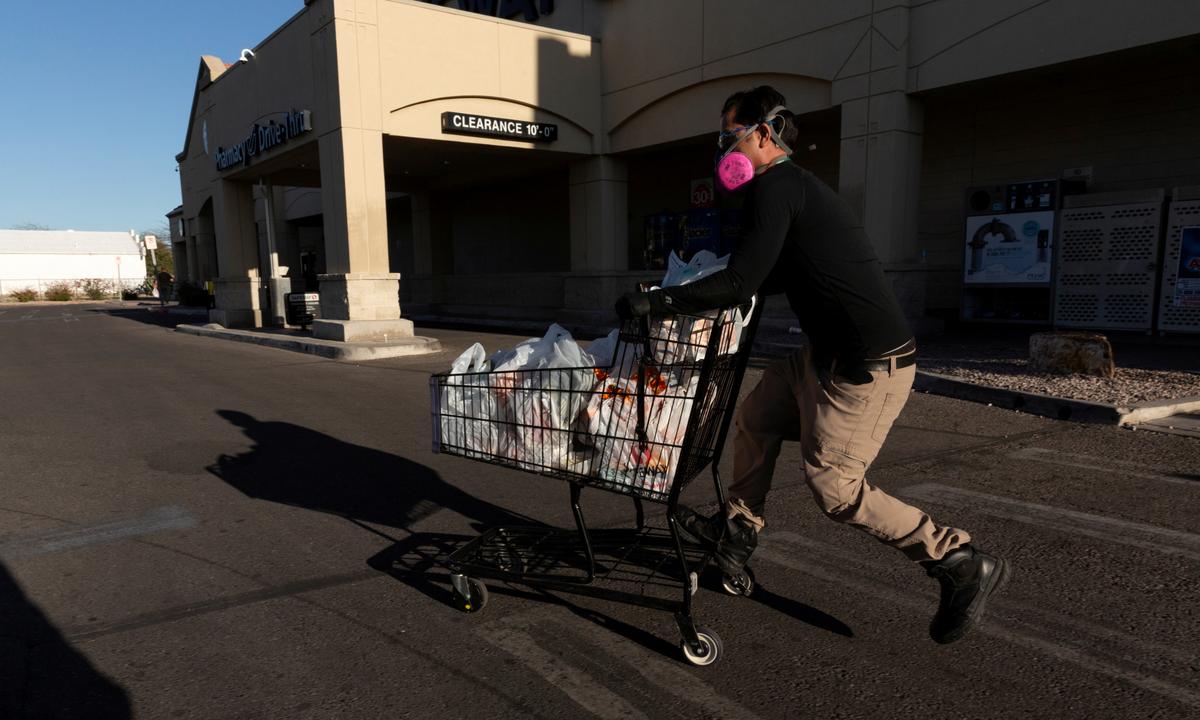 Instacart employee Eric Cohn, 34, heads to his car outside a Safeway grocery store while wearing a respirator mask to help protect himself and slow the spread of the CCP virus disease in Tucson, Ariz., U.S. on April 4, 2020. (Cheney Orr/Reuters)