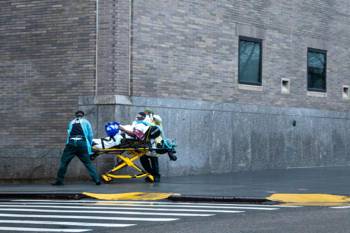 EMS workers transport a patient outside of Mount Sinai hospital in New York City, on April 13, 2020. (David Dee Delgado/Getty Images)
