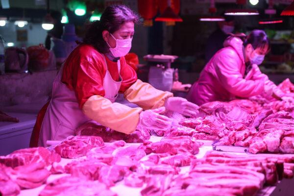 A vendor waits for customers at a meat stall in a market in Shenyang in China's northeastern Liaoning province, China, on April 10, 2020. (STR/AFP via Getty Images)