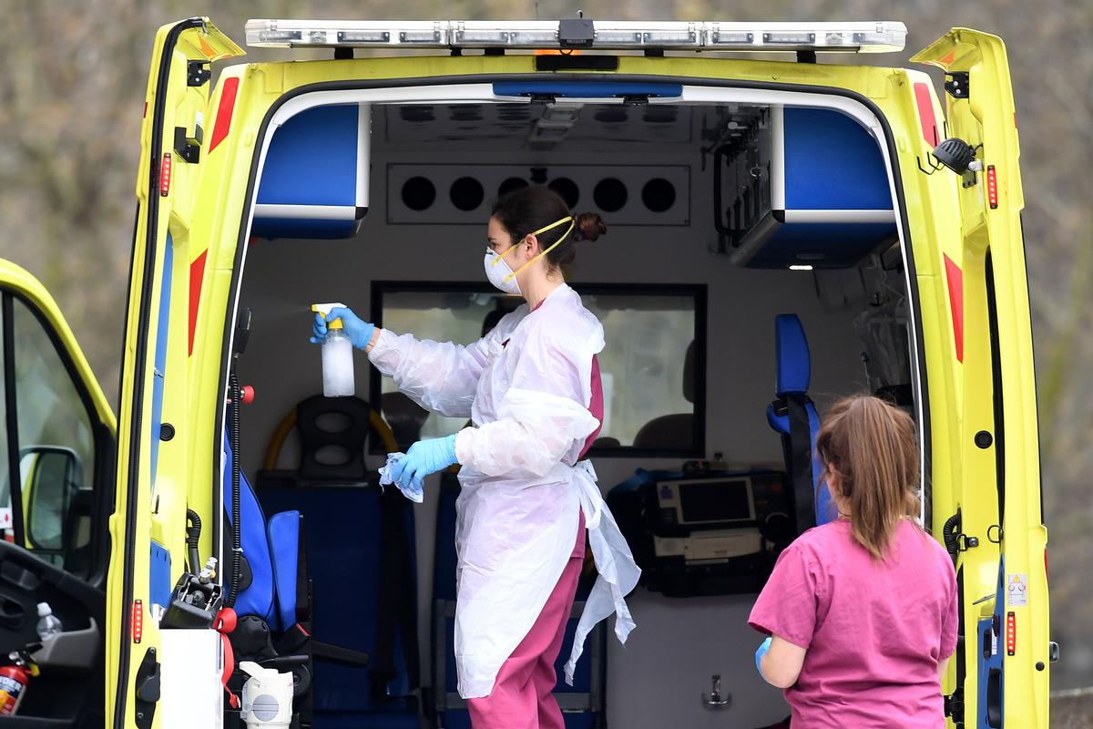 Staff disinfect an ambulance after it arrived with a patient at St Thomas' Hospital in north London, England, on April 1, 2020 (DANIEL LEAL-OLIVAS/AFP via Getty Images)