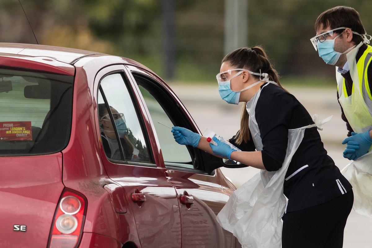 A nurse takes a swab at a COVID-19 drive-through testing station in Chessington, UK, on March 30, 2020. (Dan Kitwood/Getty Images)