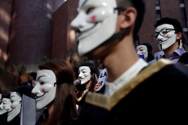 University students wearing Guy Fawkes masks pose during a news conference to support pro-democracy protests before their graduation ceremony at the Hong Kong Polytechnic University in Hong Kong, China, on Nov. 5, 2019. (Shannon Stapleton/Reuters)