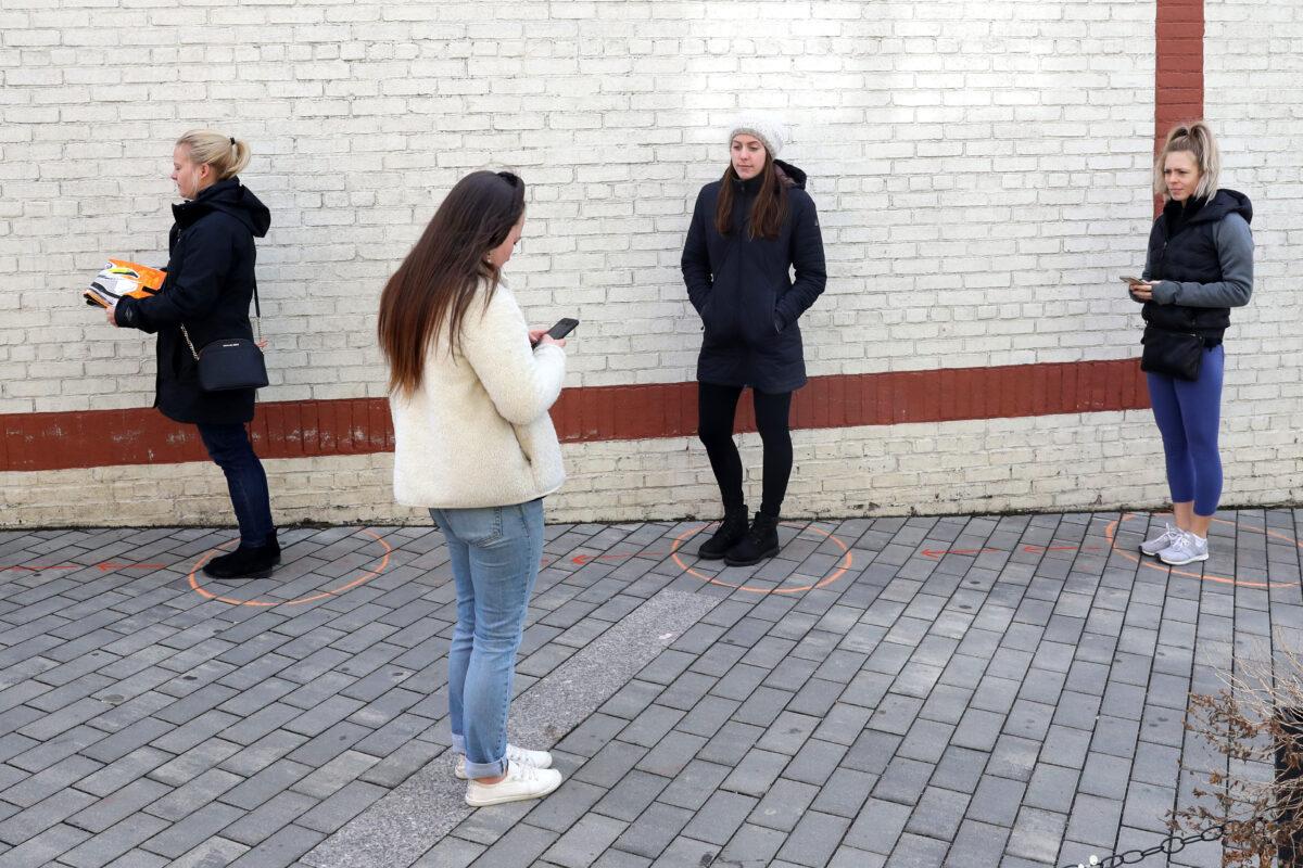Patrons observe social distancing guidelines as they wait in line at an outdoor grocery store in Somerville, Massachusetts, on March 21, 2020. (Maddie Meyer/Getty Images)