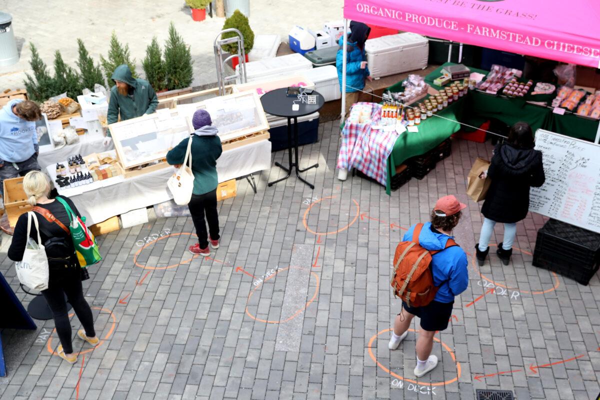 Shoppers stand on designated spots some 6 feet apart as they wait in line at the Safe Supply outdoor grocery store in Somerville, Mass., on March 21, 2020. (Maddie Meyer/Getty Images)