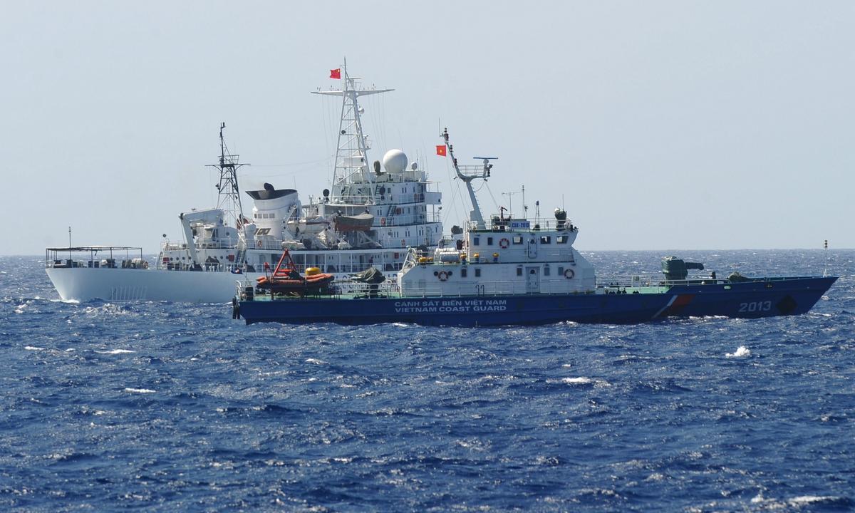 A Chinese coast guard ship (back) sails next to a Vietnamese coast guard vessel (front) near China's oil drilling rig in disputed waters in the South China Sea on May 14, 2014. (Hoang Dinh Nam/AFP via Getty Images）