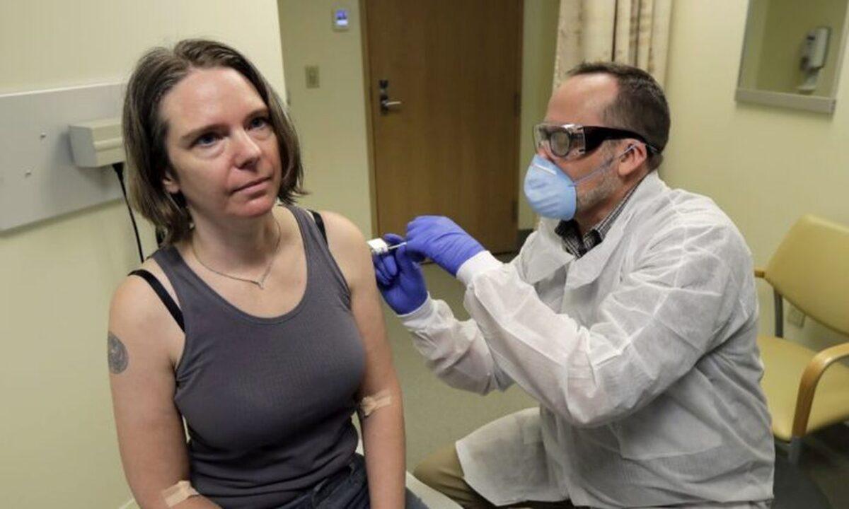 A pharmacist gives Jennifer Haller the first shot in the first-stage safety study clinical trial of a potential vaccine for COVID-19 at the Kaiser Permanente Washington Health Research Institute in Seattle on March 16, 2020. (Ted S. Warren/AP Photo)