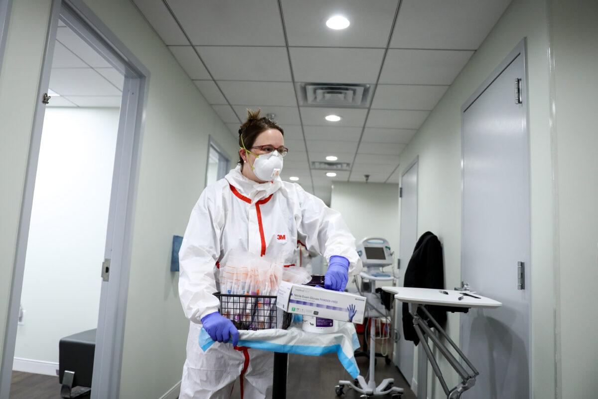 Dr. Jody Cousins prepares CCP virus sample collection kits at an AllCare Family Medical Clinic, a site that conducts drive-through testing for the CCP virus, in Washington on April 6, 2020. (Samira Bouaou/The Epoch Times)