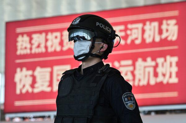 A police officer wearing a face mask stands guard at the Tianhe Airport after it was reopened today, in Wuhan in China's central Hubei province on April 8, 2020. (Hector Retamal/AFP via Getty Images)