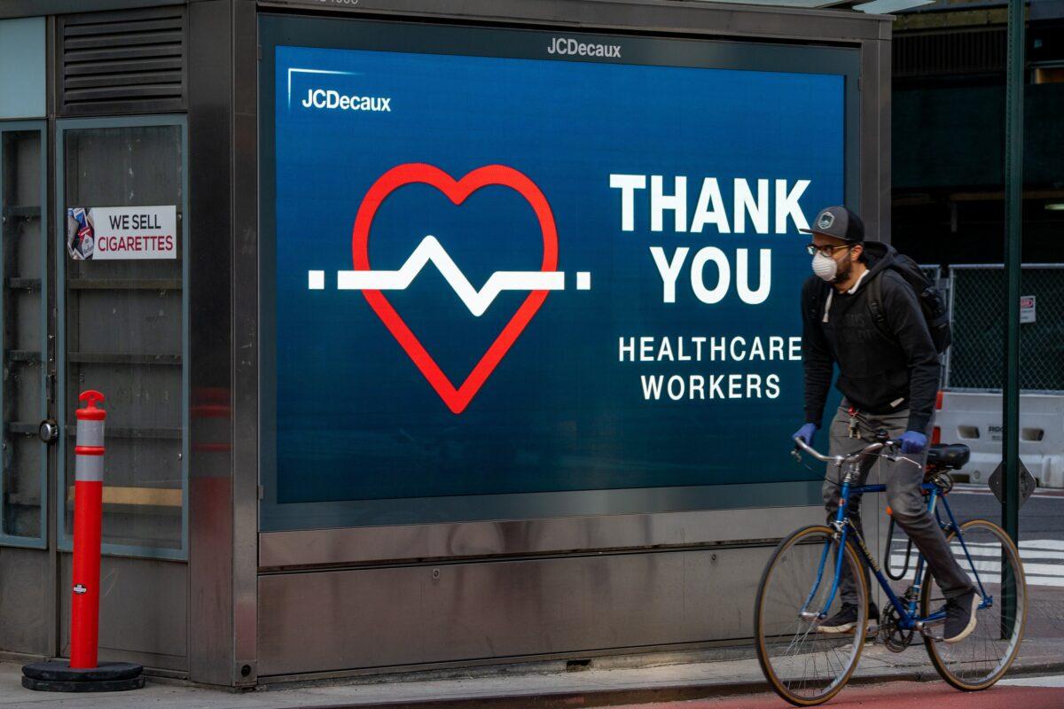 A cyclist rides by a digital billboard that thanks heath workers in New York City on April 14, 2020. (David Dee Delgado/Getty Images)