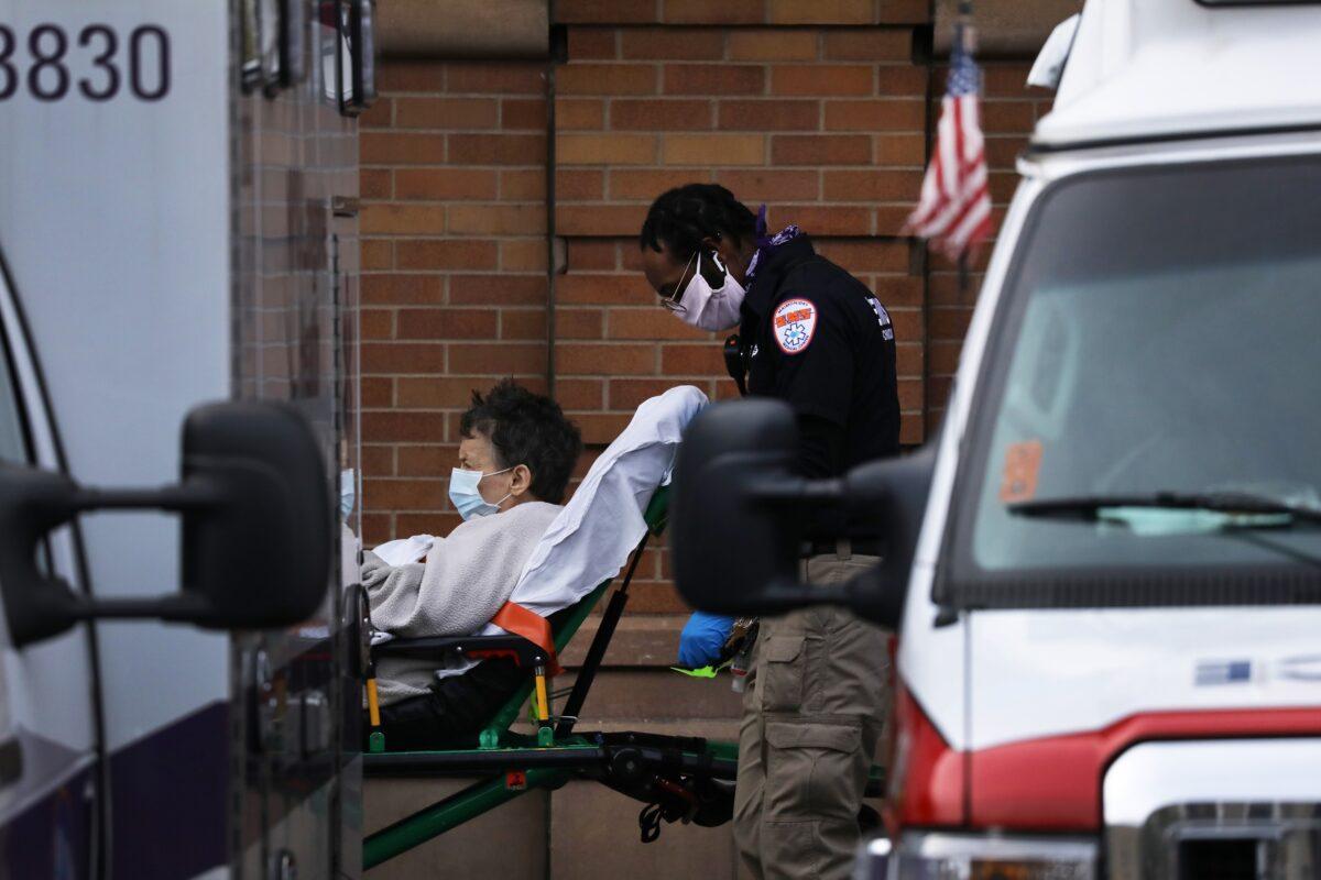 Medical workers assist patients outside a special CCP virus intake area at Maimonides Medical Center in Brooklyn, New York City, on April 14, 2020. (Spencer Platt/Getty Images)