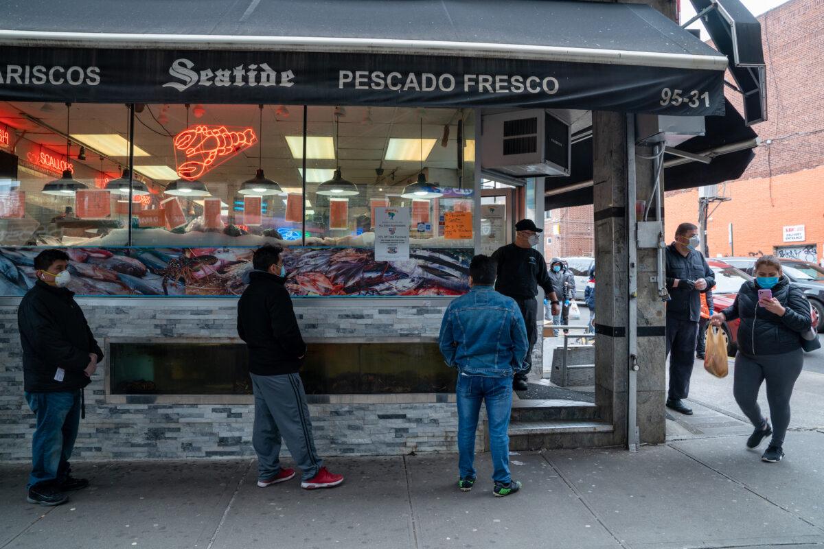 People stand in line outside a fish market in New York City on April 10, 2020. (David Dee Delgado/Getty Images)