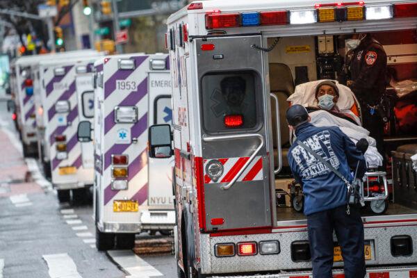 A patient arrives in an ambulance cared for by medical workers wearing personal protective equipment due to COVID-19 concerns outside NYU Langone Medical Center in New York on April 13, 2020. (John Minchillo/AP)