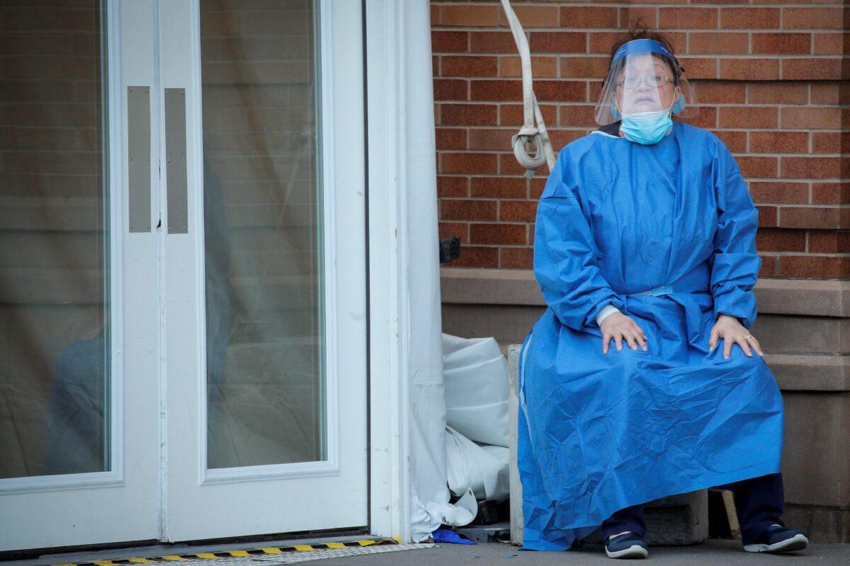 A healthcare worker takes a break outside the emergency center at Maimonides Medical Center during the outbreak of the CCP virus in the Brooklyn borough of New York on April 14, 2020. (Brendan McDermid/Reuters)