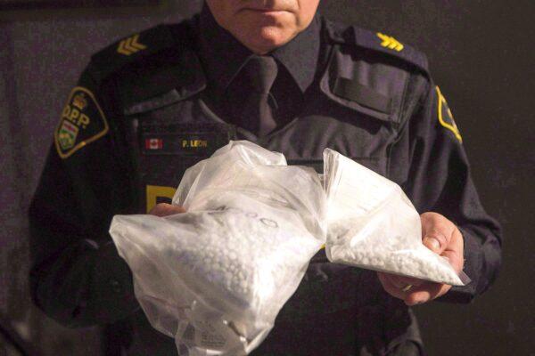 An Ontario Provincial Police officer displays bags of fentanyl during a news conference in Vaughan, Ont., on Feb. 23, 2017. (The Canadian Press/Chris Young)
