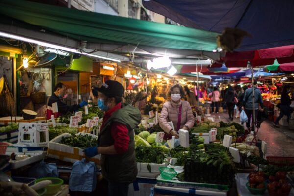 A woman wearing a face mask, amid concerns of the COVID-19 coronavirus, shops at a fresh food market in Hong Kong, China, on April 5, 2020. (Dale De Le Rey/AFP via Getty Images)