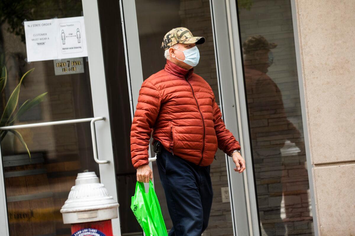 A customer leaves a liquor store while wearing a mask in Jersey City, New Jersey on April 10, 2020. (Kena Betancur/Getty Images)