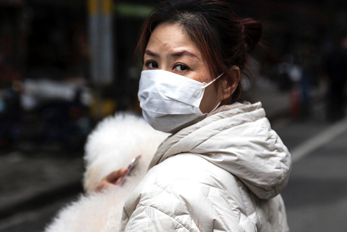 A woman holding a dog in the street in Wuhan, Hubei Province, China, on April 11, 2020. (Getty Images)