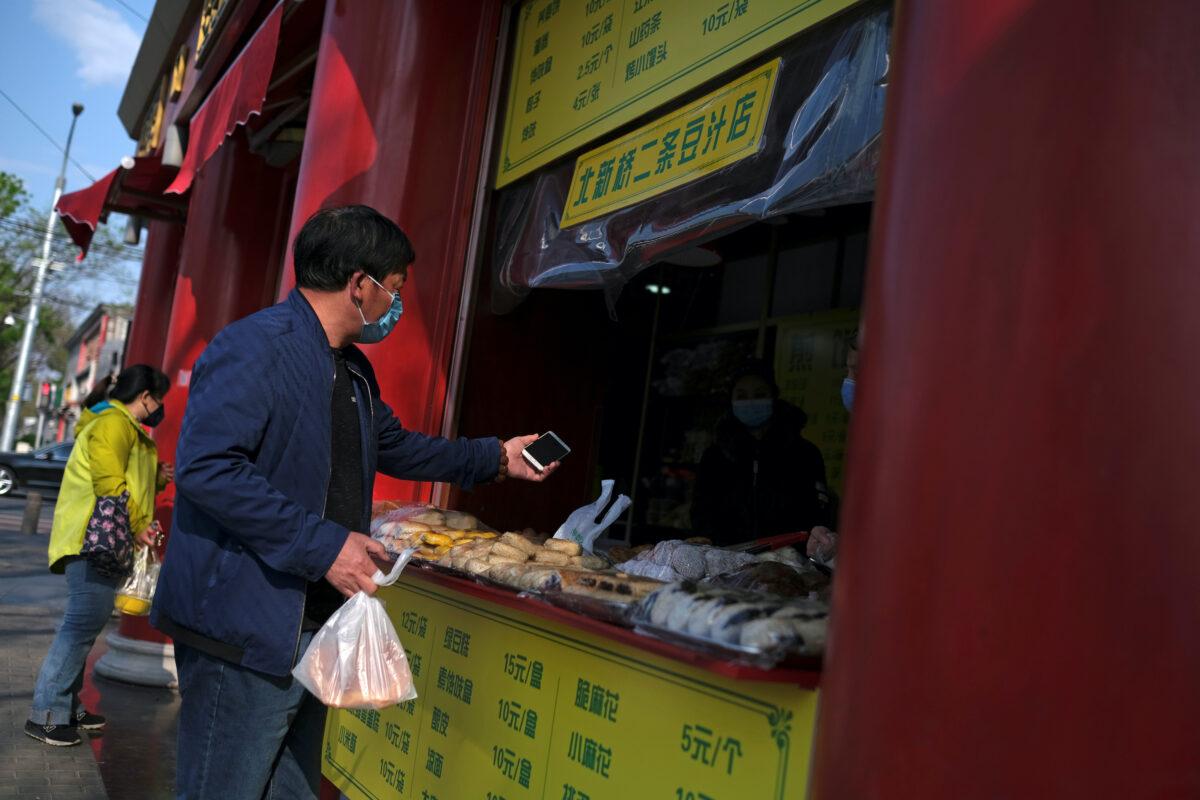 People wearing face masks buy food at a restaurant in Beijing, following an outbreak of the COVID-19 disease in China on April 17, 2020. (Carlos Garcia Rawlins/Reuters)