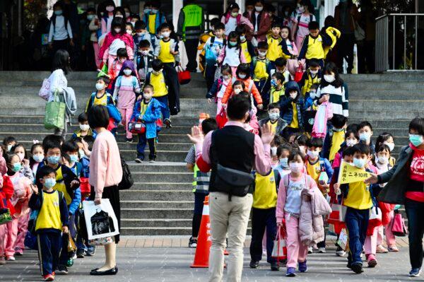 Children wearing face masks leave their elementary school at the end of the day in Xindian District, New Taipei, Taiwan, on March 3, 2020. (Sam Yeh/AFP/Getty Images)
