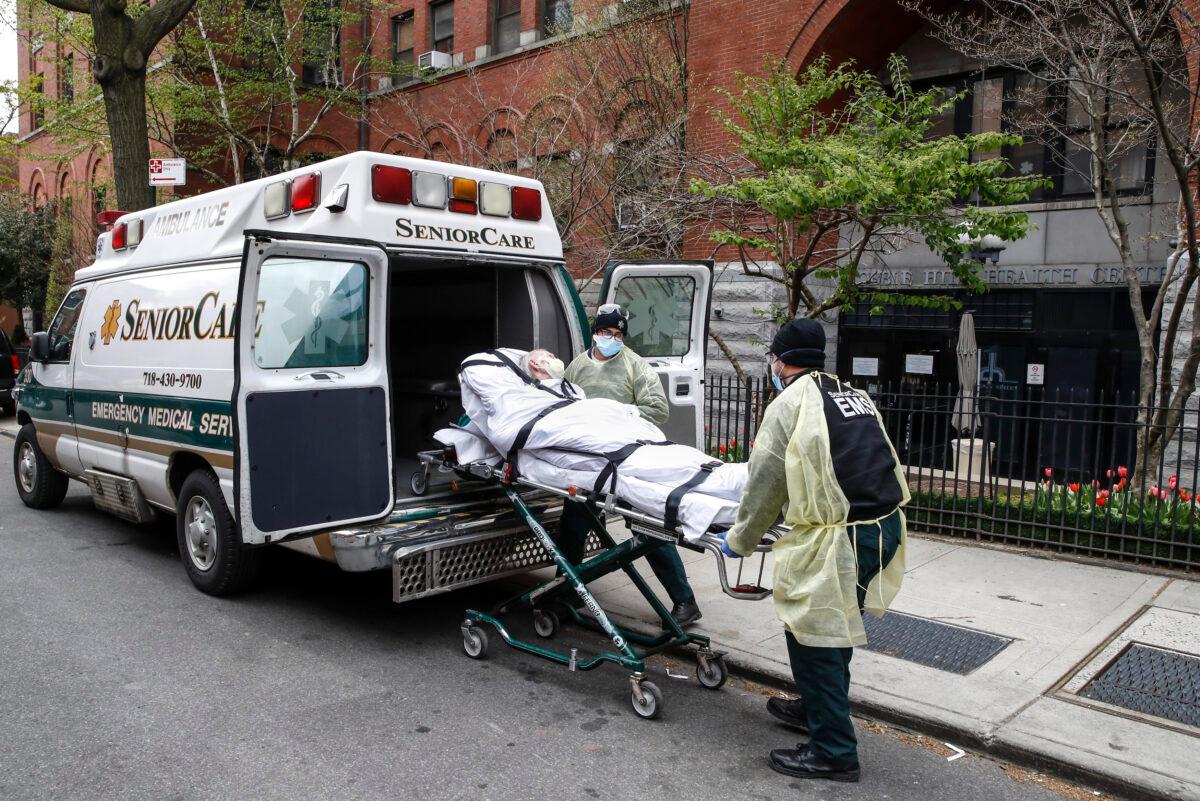 A patient is loaded into the back of an ambulance by emergency medical workers outside Cobble Hill Health Center in the Brooklyn borough of New York City on April 17, 2020. (John Minchillo/AP Photo)