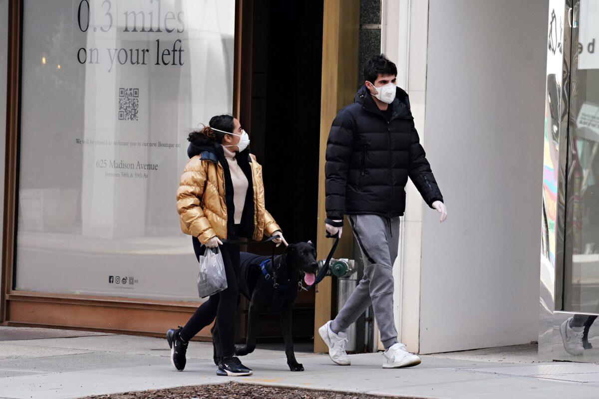 Two people walk a dog during the COVID-19 pandemic in New York City on April 16, 2020. (Cindy Ord/Getty Images)