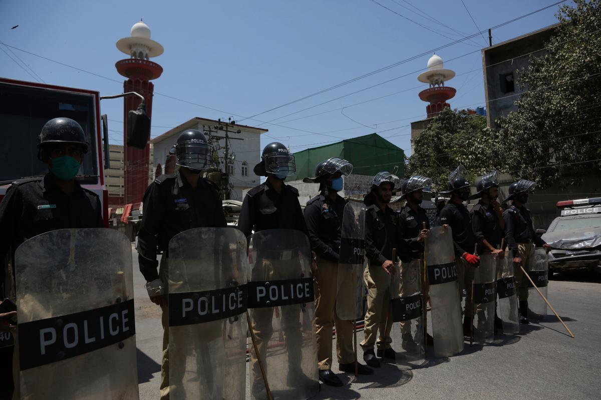 Police officers stand guard outside a mosque during a nation-wide lockdown as a preventive measure against the outbreak of CCP virus, in Karachi, Pakistan, April 17, 2020. (Fareed Khan/AP Photo)