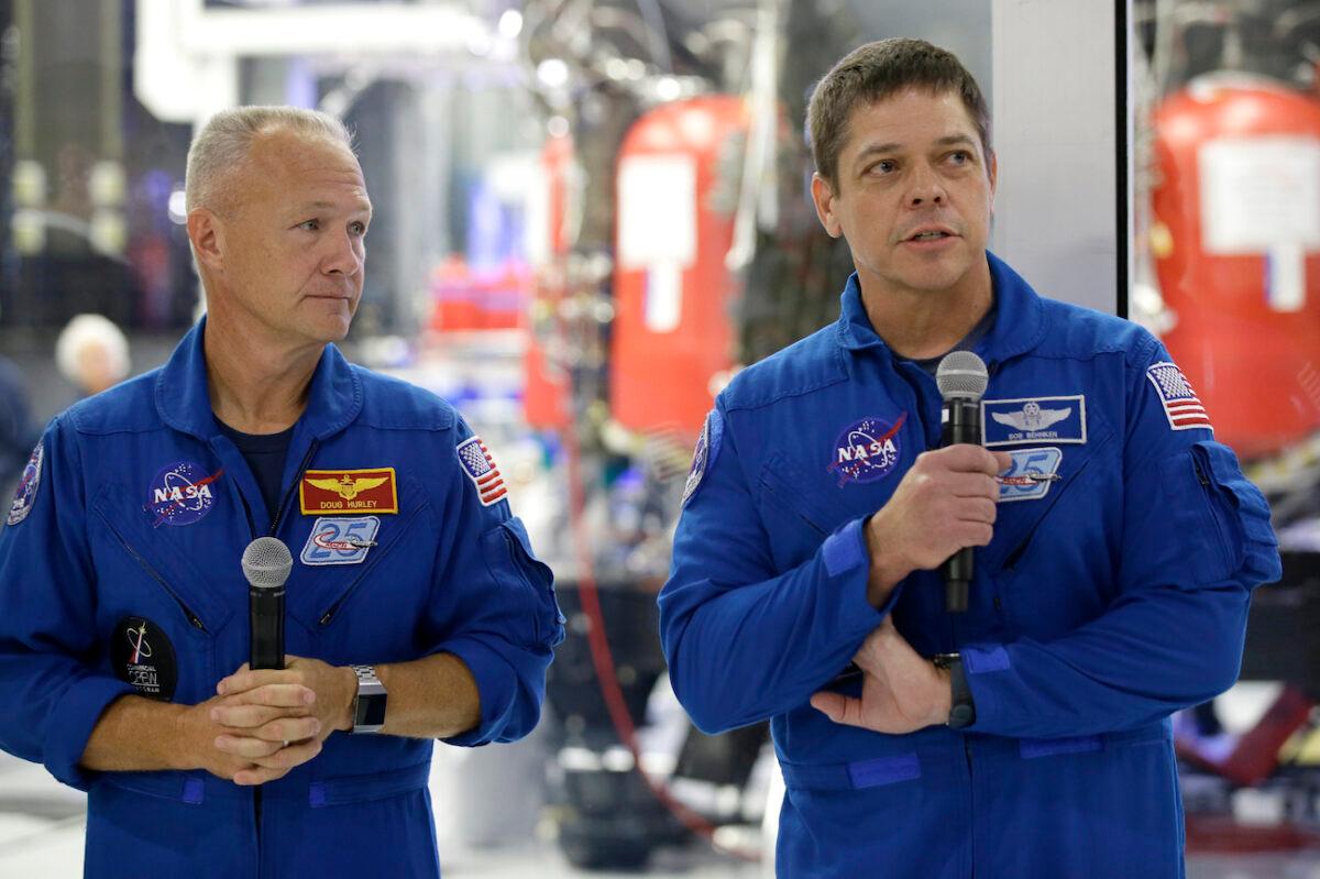 NASA astronauts Bob Behnken (R) with Doug Hurley talk to the media in front of the Crew Dragon spacecraft, about the progress to fly astronauts to and from the International Space Station, from American soil, as part of the agency’s commercial crew program at SpaceX headquarters, in Hawthorne, Calif., on Oct. 10, 2019. (Alex Gallardo/AP Photo)