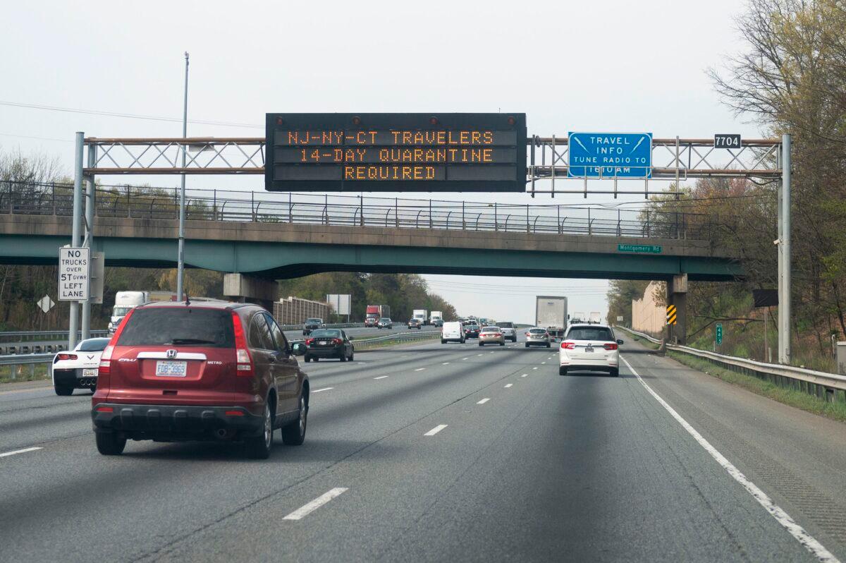 Cars drive below a sign on the highway notifying travelers from New York, New Jersey, or Connecticut that they are required to quarantine for 14 days, in Millersville, Maryland on April 17, 2020. (Andrew Caballero-Reynolds/AFP via Getty Images)