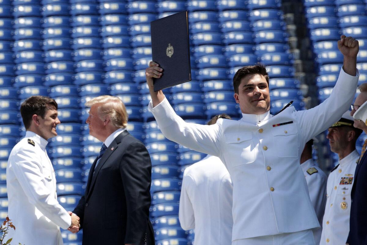 A U.S. Navy graduate celebrates after he received his diploma as President Donald Trump shakes hands with another graduate during a graduation ceremony at the Navy-Marine Corps Memorial Stadium of the U.S. Naval Academy in Annapolis, Maryland, on May 25, 2018. (Alex Wong/Getty Images)